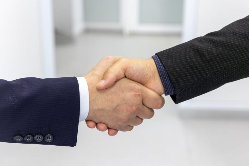 Home Close-up of a handshake in a business environment, symbolizing partnership.
