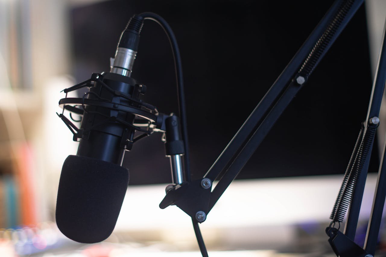 Close-up of a condenser microphone in a studio setting, ideal for podcasts and audio recording.